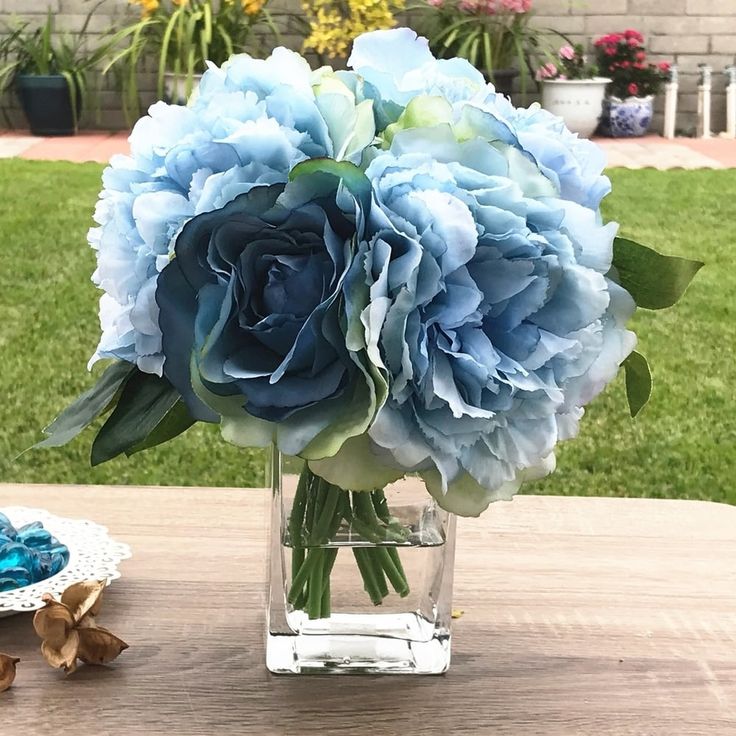 a vase filled with blue flowers on top of a wooden table