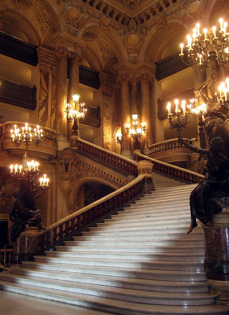 an ornate staircase with chandeliers and statues