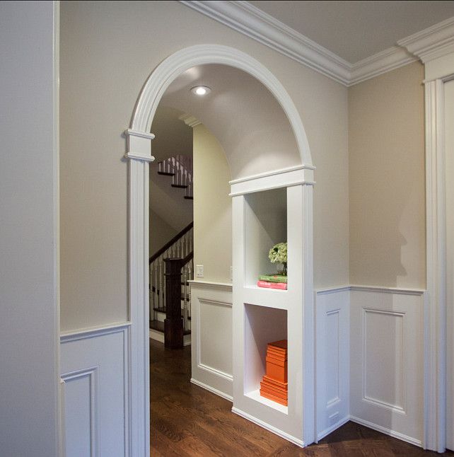 an empty room with wood floors and white walls, along with a wooden door leading to the second floor