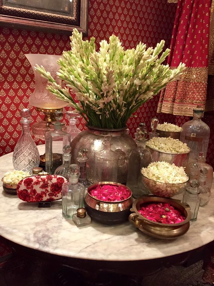 a table topped with lots of vases filled with flowers and other items on top of it