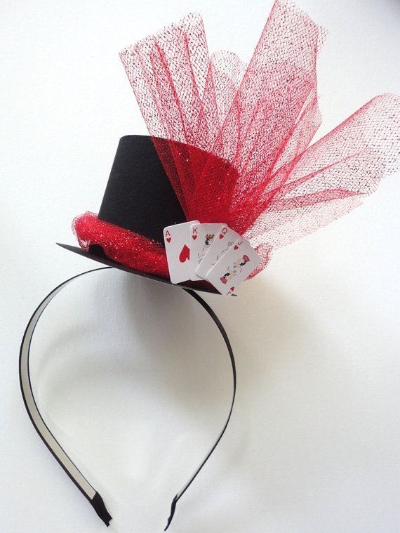 a red and black top hat with cards on it's headband, sitting on a white surface