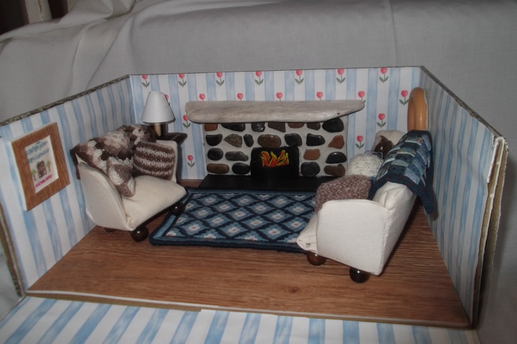 a dollhouse living room with two chairs and a fireplace