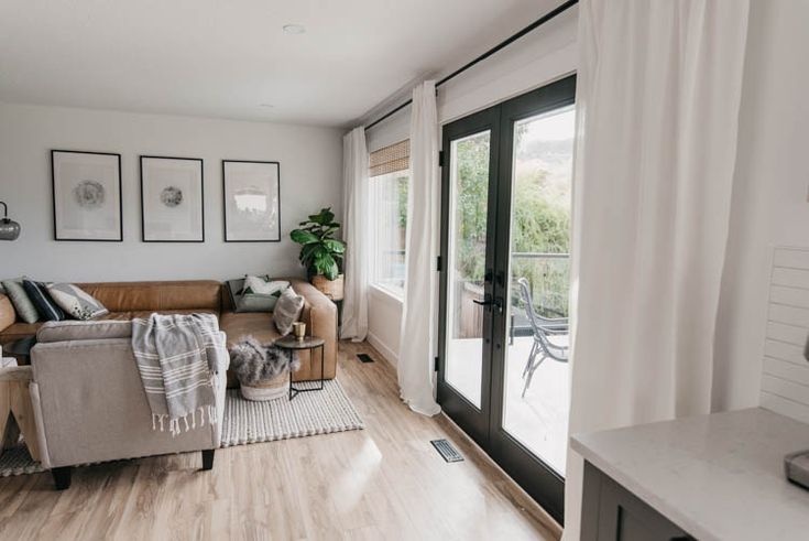 a living room filled with furniture and pictures hanging on the wall next to a sliding glass door