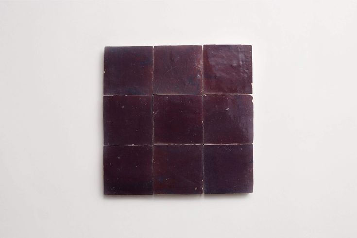 a square piece of purple soap sitting on top of a white surface