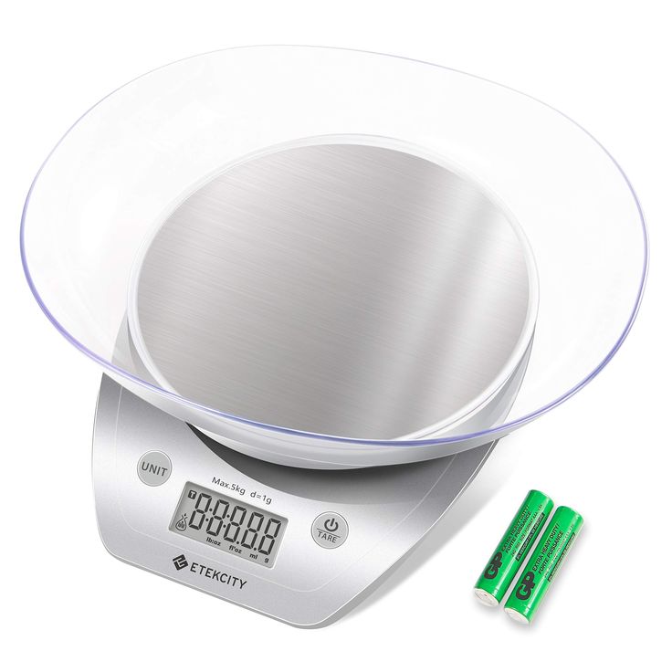 an electronic scale with two batteries on it and a glass bowl in the middle that is empty