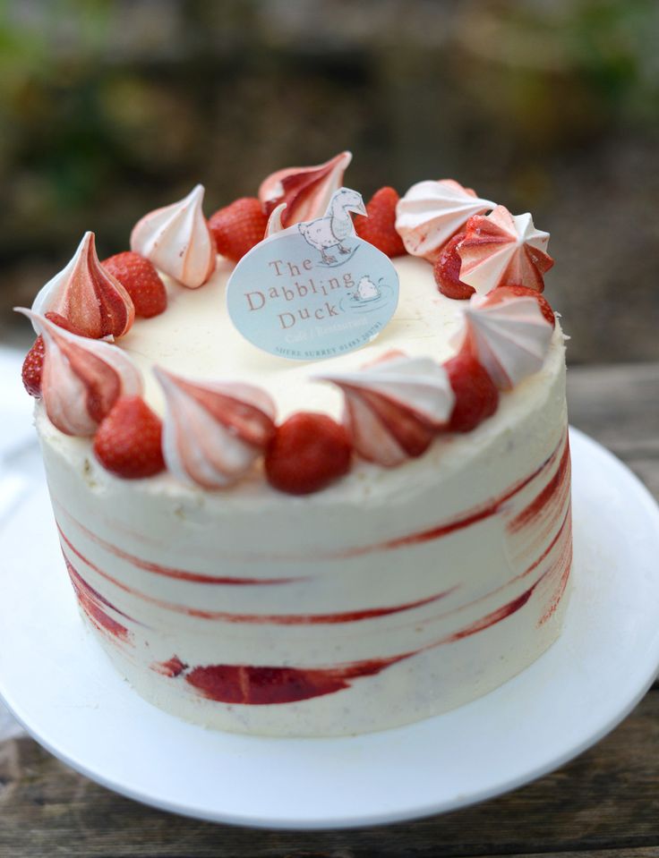 a cake with white frosting and strawberries on top