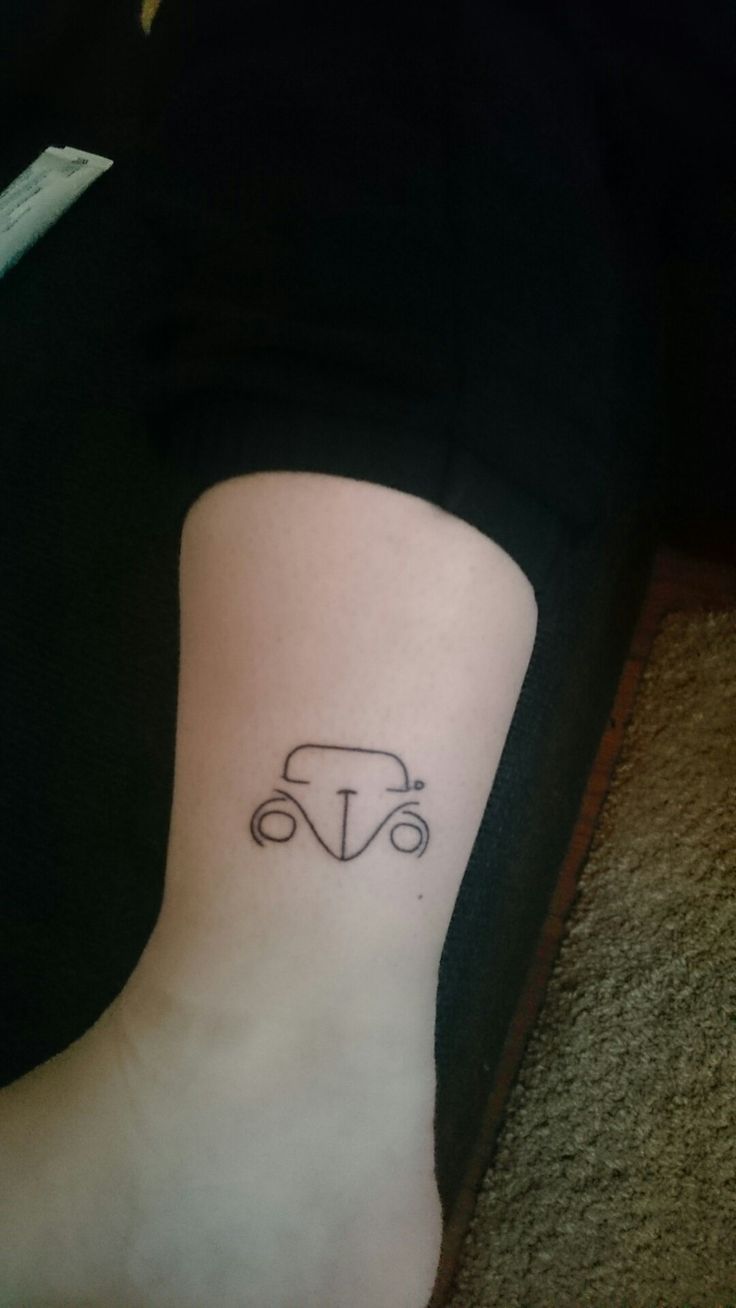 a woman's foot with a small car tattoo on her left side calf area