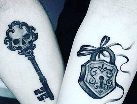 two people with tattoos on their arms holding keys and a key to each other's heart