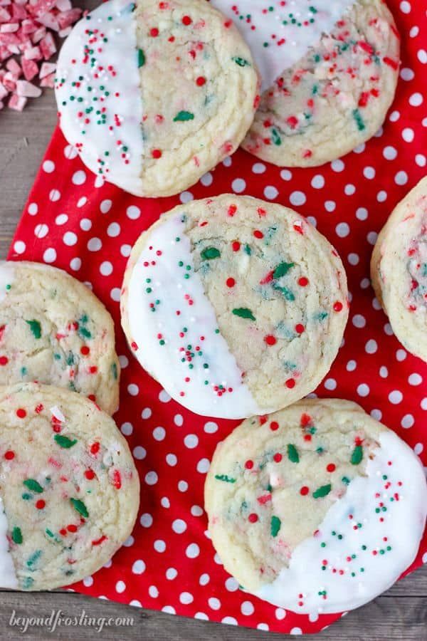 cookies with white frosting and sprinkles on a red polka dot cloth