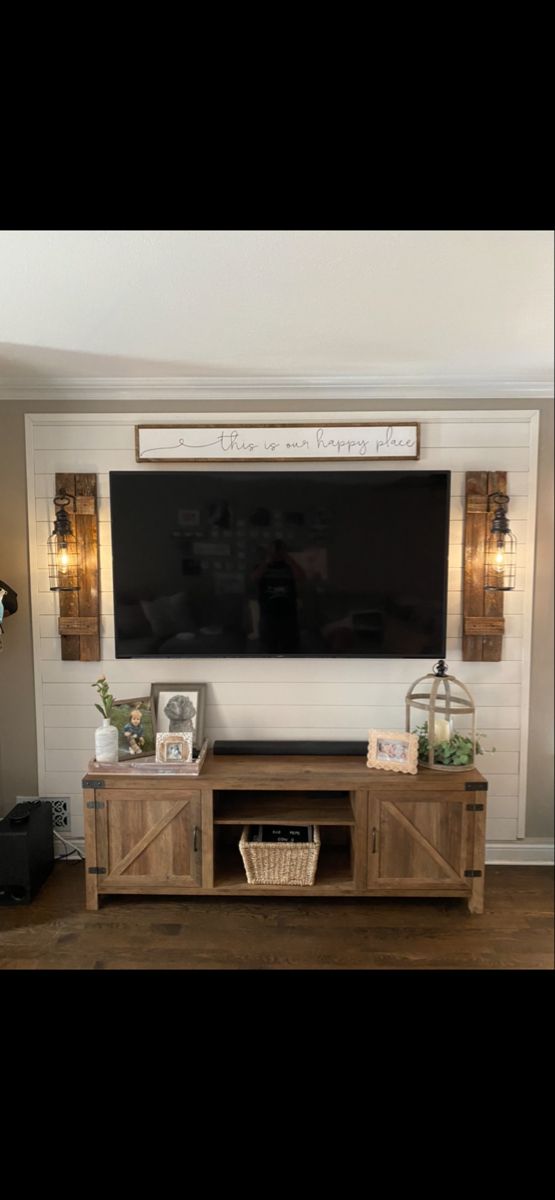 a large flat screen tv mounted to the side of a wooden entertainment center in a living room