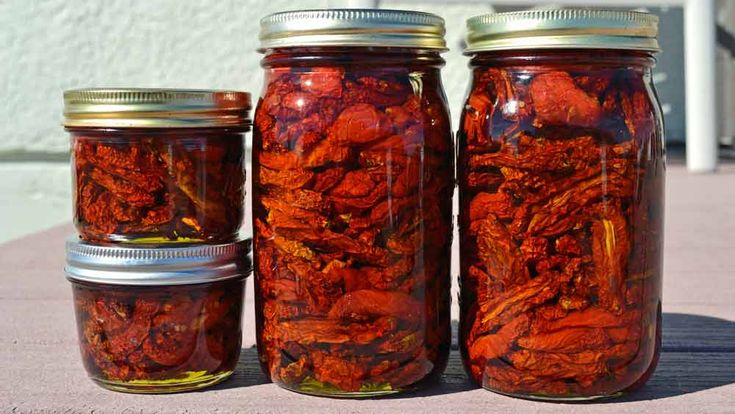 three jars filled with red liquid sitting on top of a table