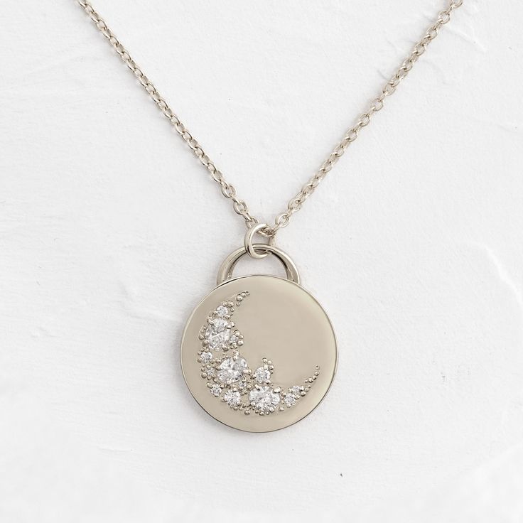 This solid 14k gold pendant is 19.5mm in diameter and 2mm thick. Also available in platinum. It features three oval diamonds (3x4mm) and ten round white diamonds (1-2mm). All accent diamonds are SI clarity and G+ color. The pendant is available on its own or with a 20" cable chain that matches your choice of metal: solid 14k gold or platinum. We handcraft each piece with responsibly sourced metals and ethically sourced stones. Engraved Sterling Silver Necklace In Diamond White, Silver 14k Gold Necklace With Diamond Accents, Luxury Silver Diamond Necklace With Oval Pendant, 14k Gold Silver Necklace With Diamond Accents, Silver 14k Gold Diamond Necklace With Single Cut Diamonds, Silver Engraved Diamond Pendant Necklace, Silver Engraved Diamond Necklace, Silver Diamond Pendant Necklace Engraved, Engraved Silver Diamond Pendant Necklace