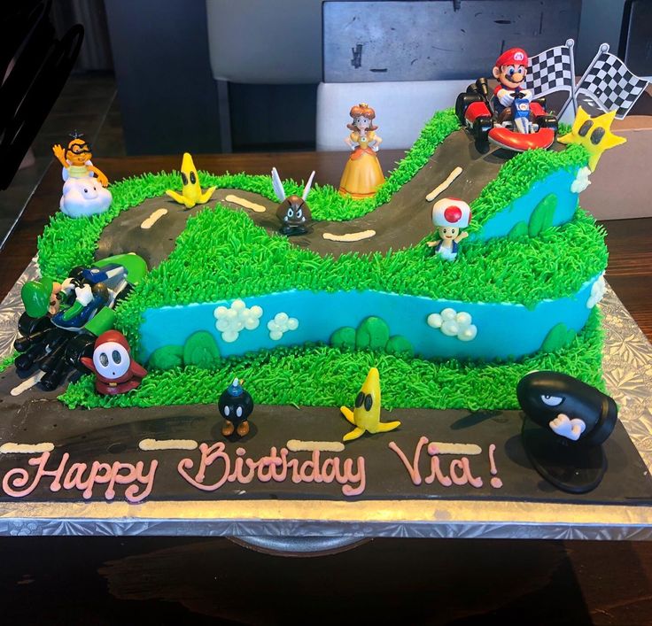 a birthday cake is decorated with mario kart and other cartoon characters on the road