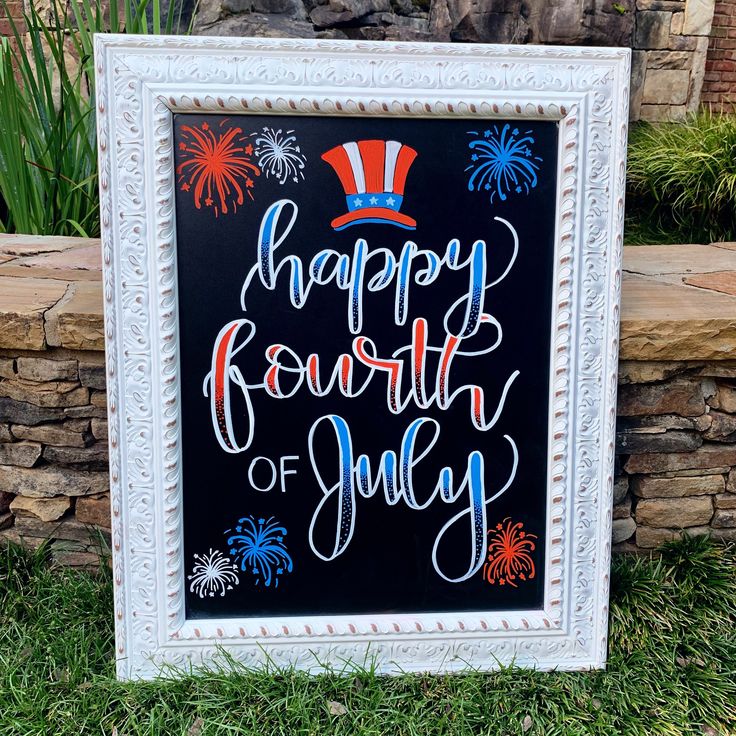 a happy fourth of july sign in front of a stone wall with grass and firework