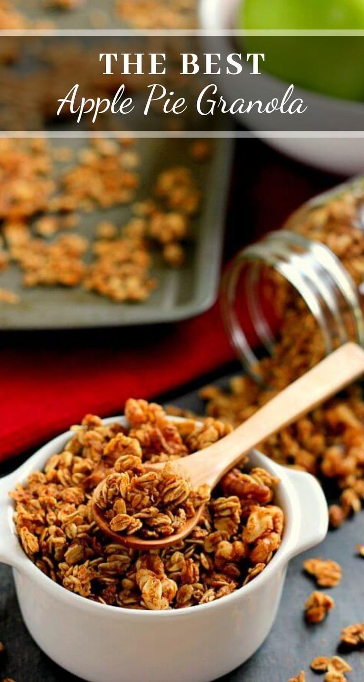 granola in a white bowl with a wooden spoon next to some apples and other food