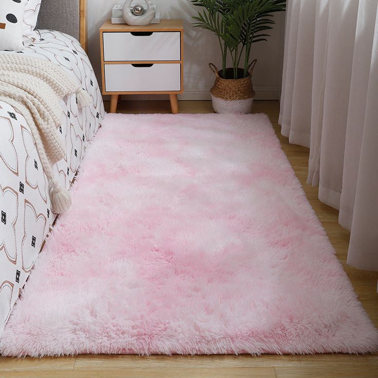 a bedroom with a pink rug on the floor