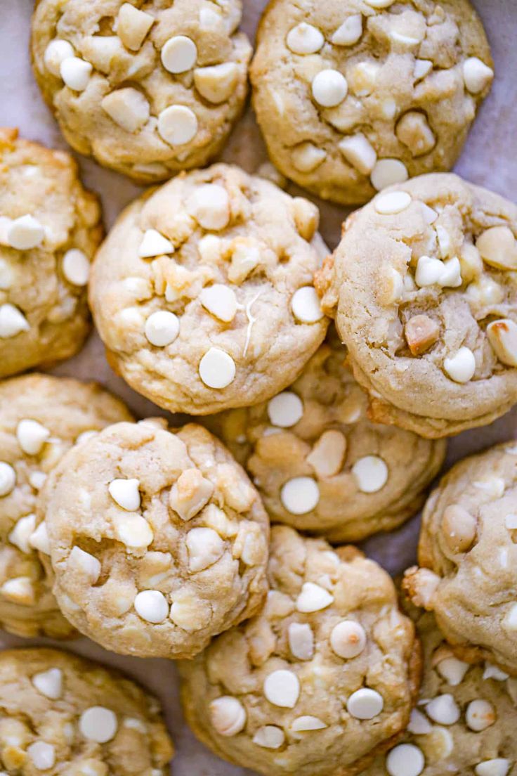 white chocolate chip cookies are piled up on top of each other