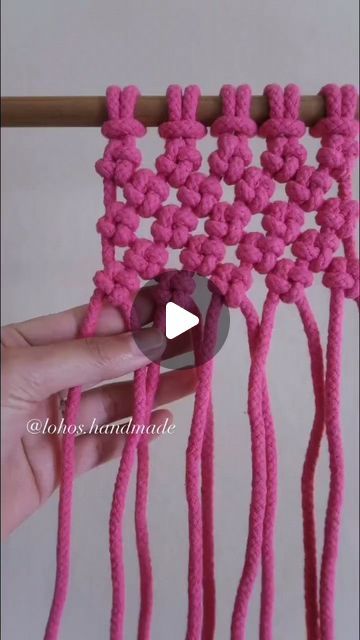 the video shows how to crochet an object with pink yarn and two hands