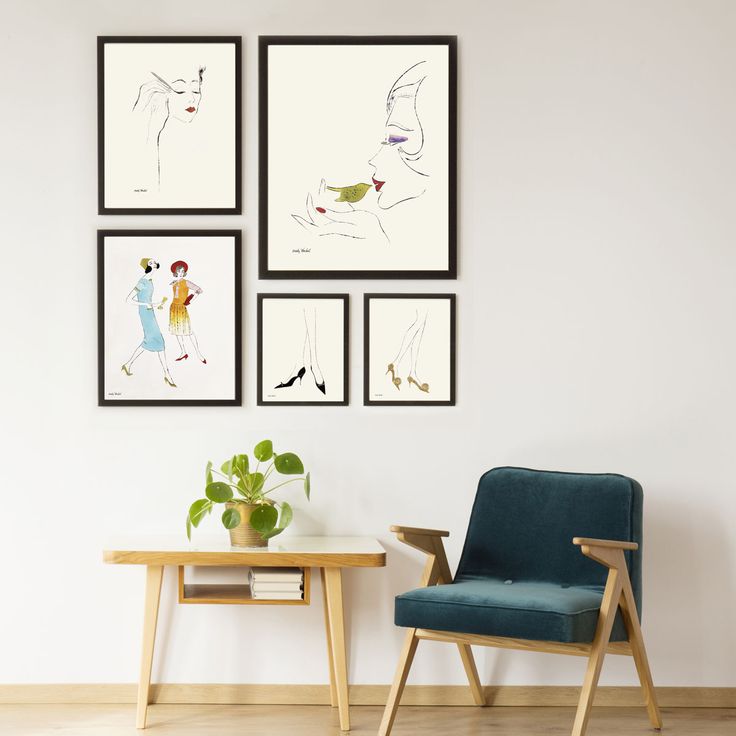 three framed pictures hang on the wall next to a table with a potted plant