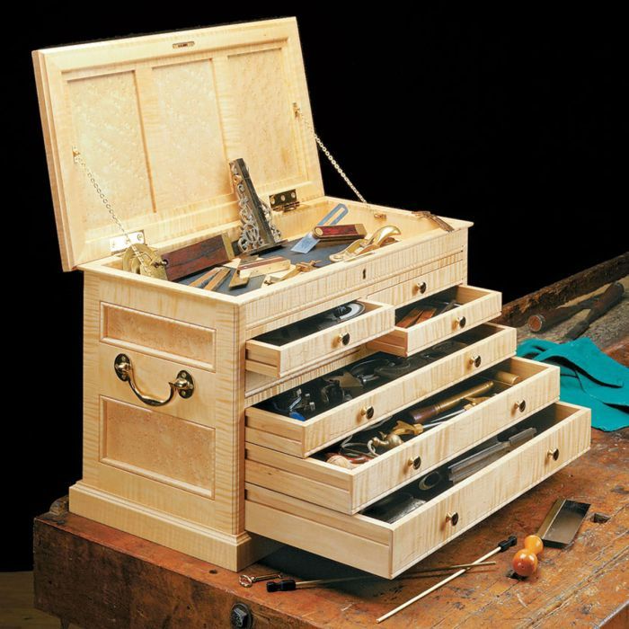 a wooden box with drawers on top of it and tools in the bottom drawer next to it