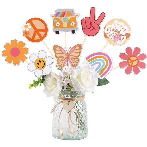 a vase filled with white flowers and paper cutouts in the shape of peace signs