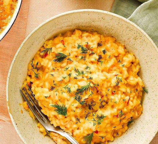 there is a bowl of macaroni and cheese with a fork in the bowl