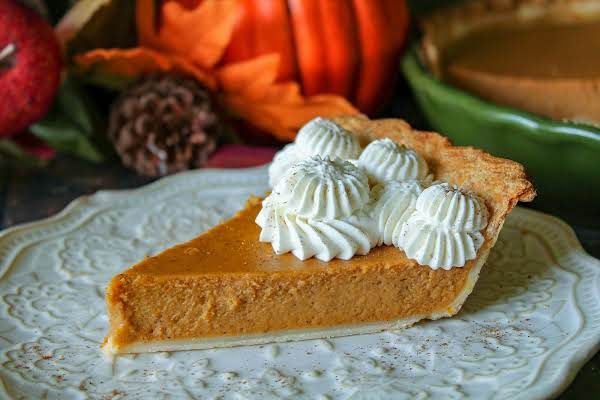 a slice of pumpkin pie with whipped cream on top