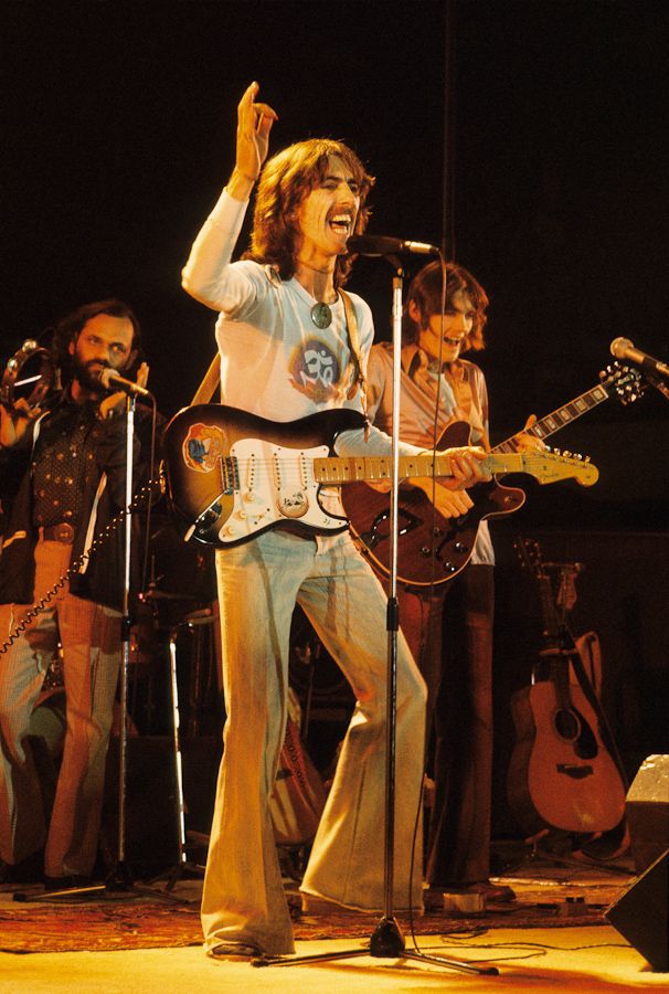 the rolling stones performing on stage with their guitars in hand and singing into microphones