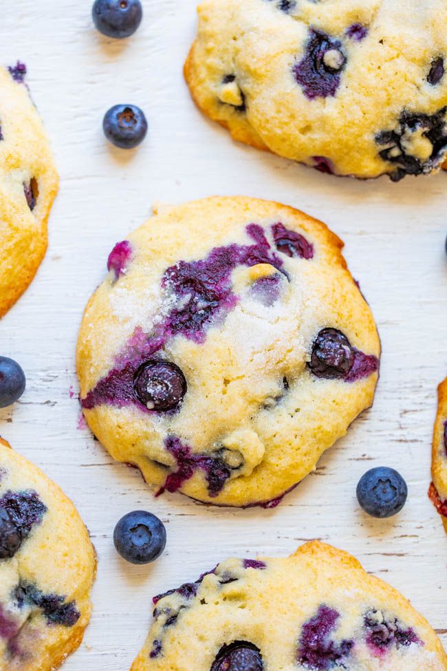 blueberry muffins on a white surface with fresh blueberries