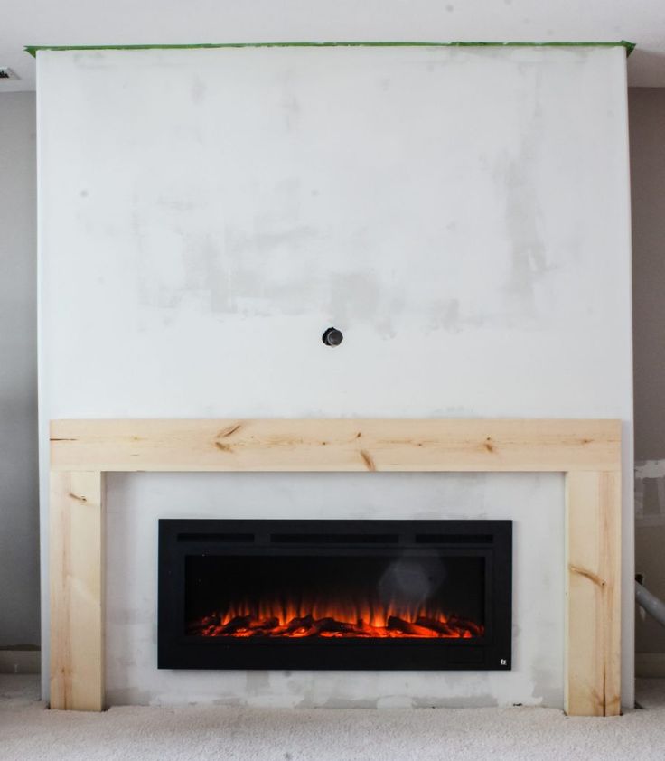 a fire place in the middle of a room with white walls and no one around it