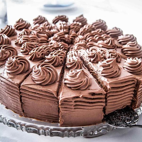 a chocolate cake with frosting on a silver platter