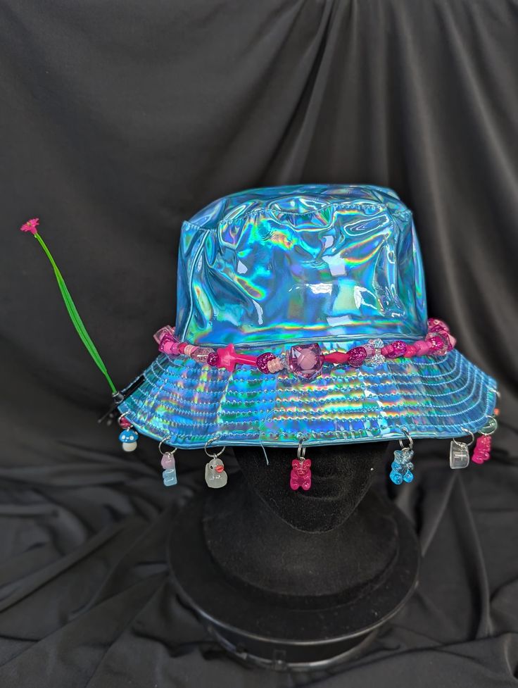 -hat color - blue -bead color - pink -charm color - blue and pink -unisex adult size -inner circumference - 22.5in -crown dip - 3in -brim - 2.25in -NOT machine washable -Perfect for raves and outdoor festivals! Shipping within the US USPS First Class Package 3-9 days USPS Priority Mail 1-5 days USPS Priority Mail Express 1-3 days Shipping International  USPS First Class Mail International  -Varies- USPS Priority Mail International 6-14 days USPS Priority Mail Express International 3-9 days Shipping times are estimated, NOT GUARENTEED.  +International buyers are responsible for all import fees+ +Orders of $50+ may require signature confirmation upon delivery+ Fun Pink Hat For Music Festival, Blue Bucket Hat With Curved Brim For Festivals, Blue Curved Brim Bucket Hat For Festival, Blue Brimmed Bucket Hat For Festival, Novelty Curved Brim Hat For Festival, Trendy Blue Hats For Festival, Trendy Blue Hat For Festival, Fun Pink Adjustable Bucket Hat, Blue Bucket Hat For Festivals