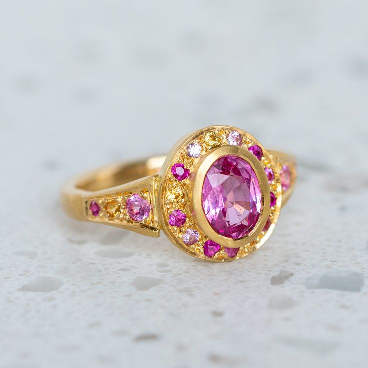 A fine grade pink sapphire has been set into our Roman Ring and is surrounded by shades of smaller pink and yellow sapphires. Centre sapphire measures 7 x 5mm and weighs 0.90ct approx. Band width 2.4mm at the back. Metal weight 6g approx. Pictured here with a matte finish. For a high shine finish please leave a note at checkout. Roman Ring, Shades Of Pink, Pink And Yellow, Instagram Icons, Yellow Sapphire, Pink Sapphire, Earings Piercings, Piercings, Sapphire