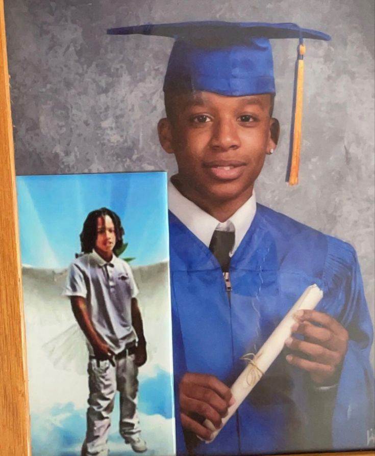 a young man wearing a graduation cap and gown holding a diploma in front of him