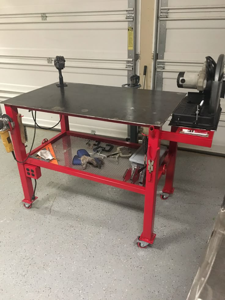 a red workbench with tools on it in front of a garage door and overhead doors