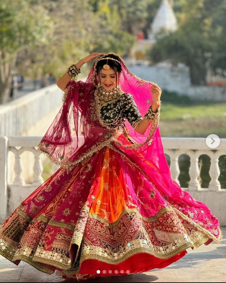 a woman in a red and orange lehenga dancing