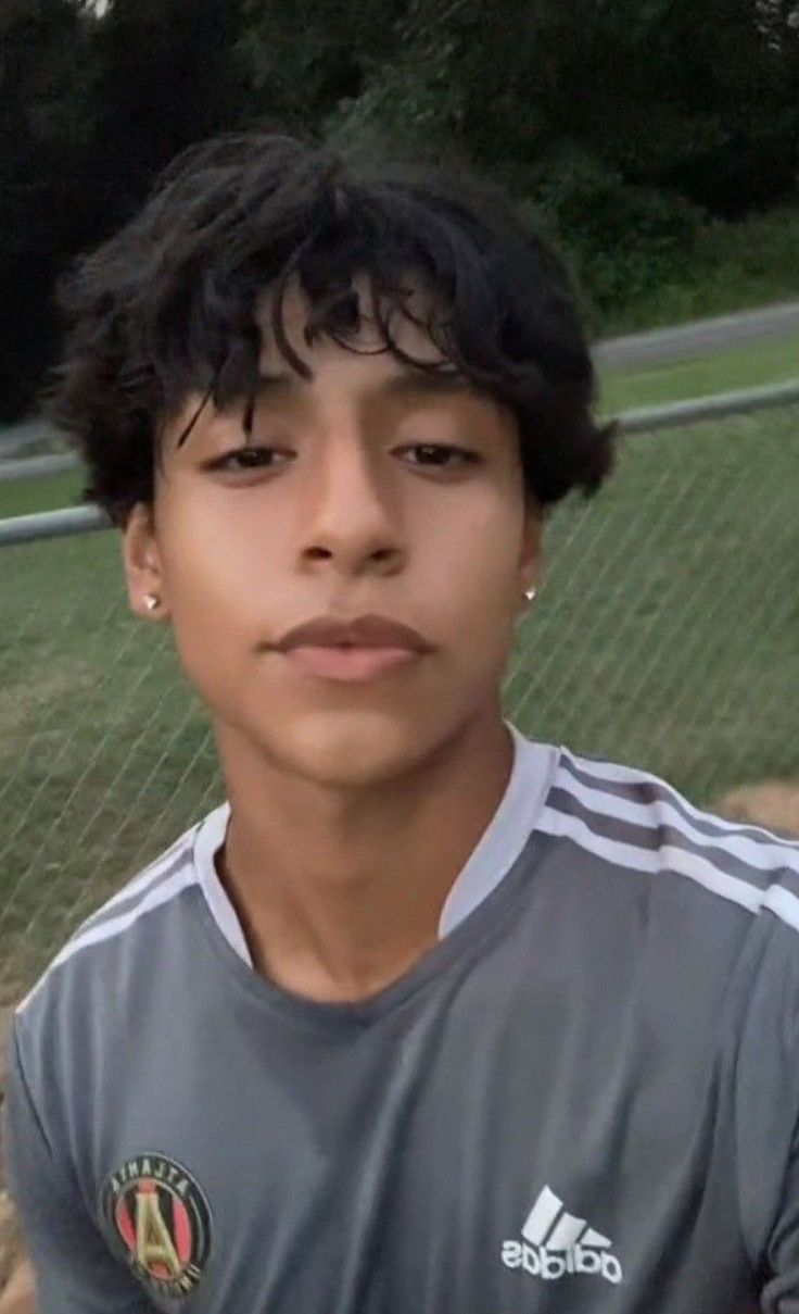 a young man in a soccer uniform posing for a photo