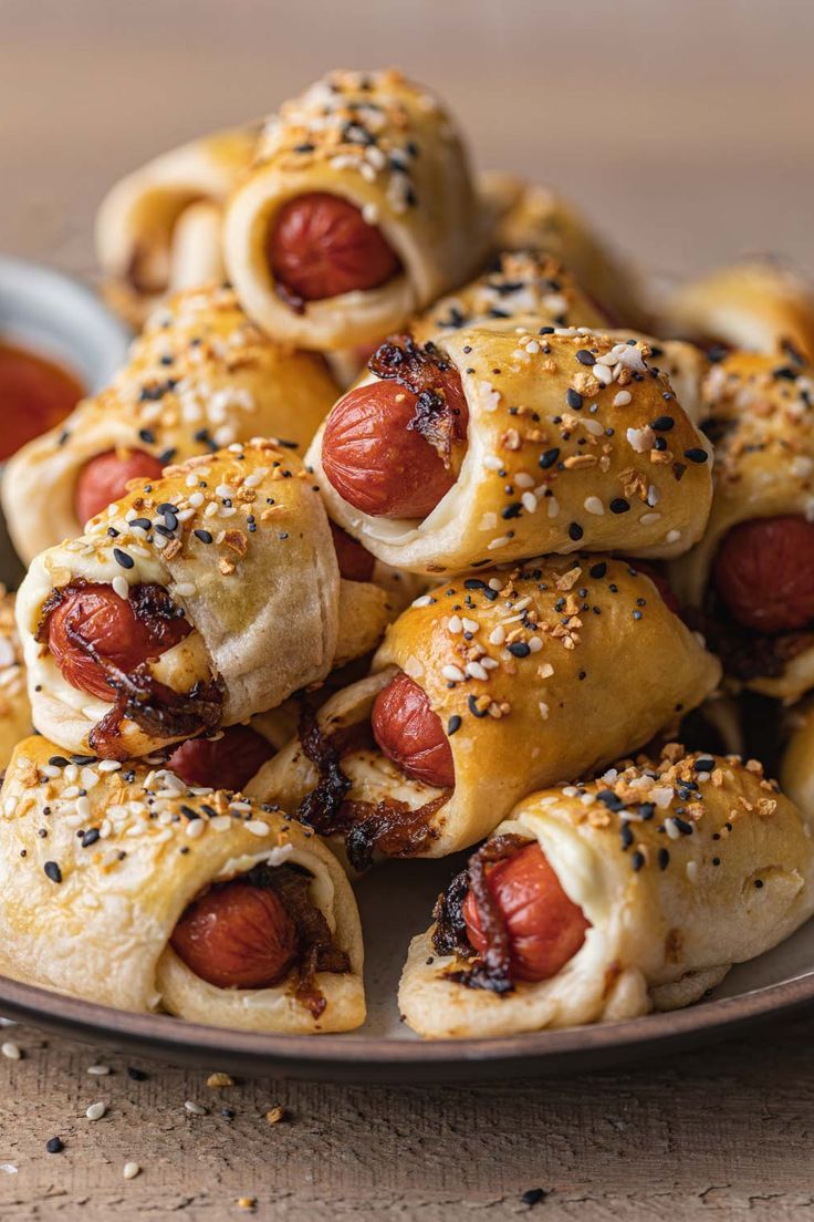 a plate full of pigs in a blanket with ketchup and mustard on top