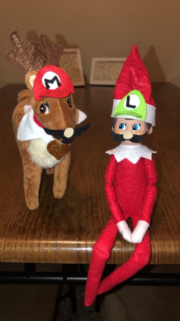 two elf dolls sitting on top of a wooden table