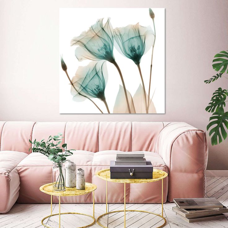 a living room with pink couches and paintings on the wall above them, along with a coffee table