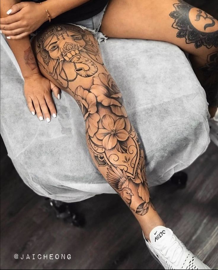 a woman sitting on top of a chair covered in tattoos