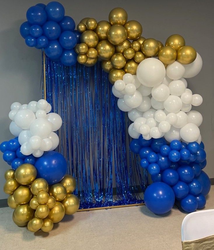 balloons and streamers are arranged in the shape of an arch