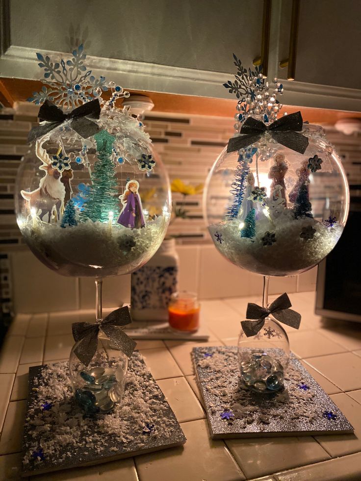 two snow globes sitting on top of a kitchen counter