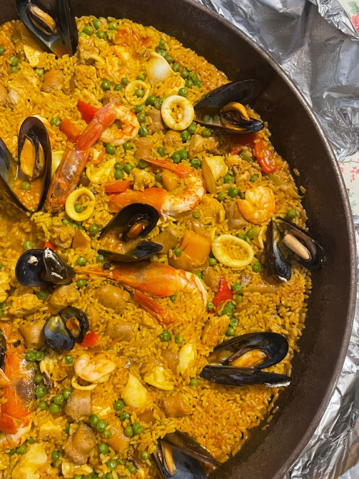 a pan filled with seafood and rice covered in sauce