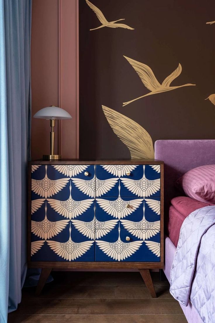 a blue and white cabinet sitting next to a bed