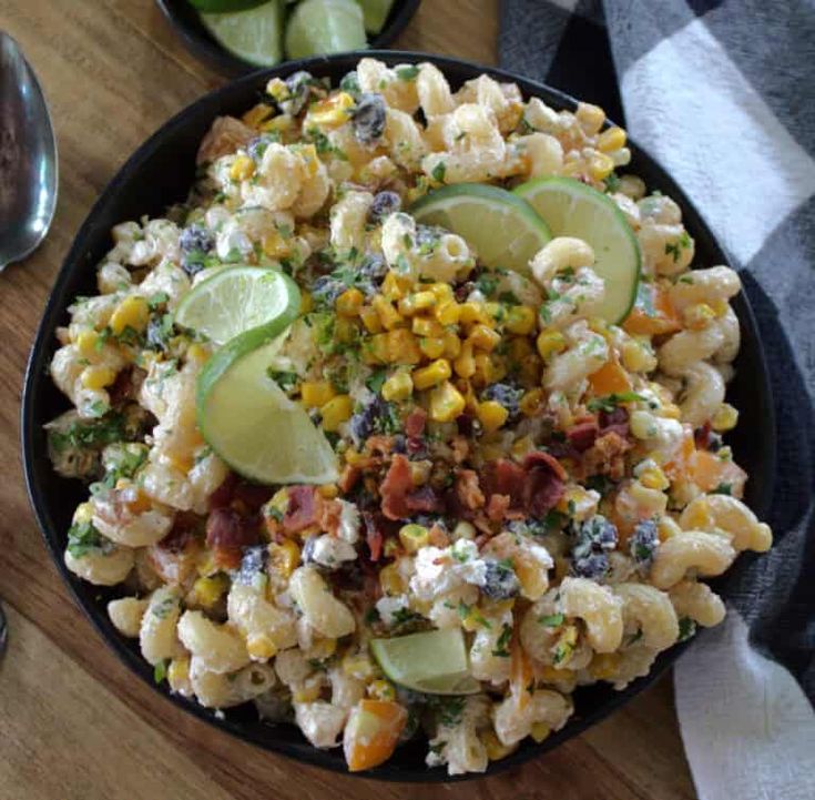 a bowl filled with macaroni salad on top of a wooden table