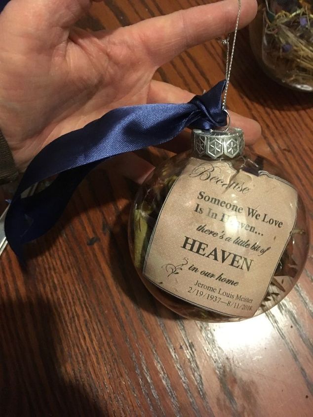 someone is holding up a glass ornament with a message on it that reads, heaven someone we love is in heaven