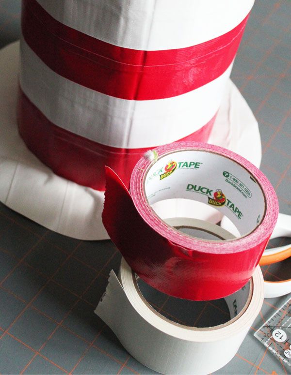 there is a roll of tape on top of a cake with red and white stripes