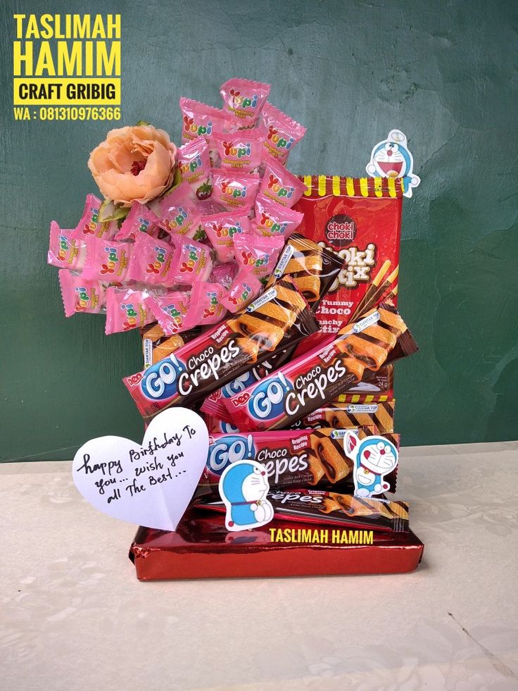 a box filled with lots of candy next to a sign that says happy valentine's day