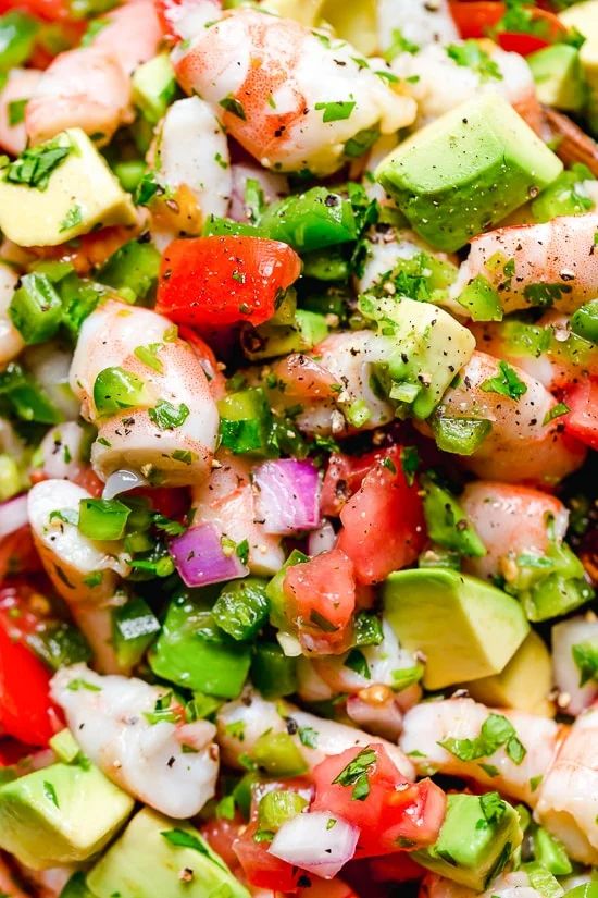 a salad with shrimp, avocado, tomatoes and cilantro in it